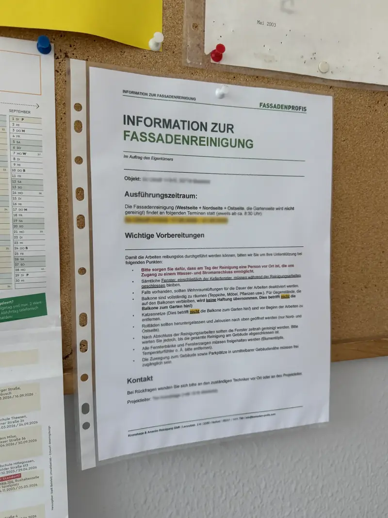 Aushang „Information zur Fassadenreinigung“ von FassadenProfis mit Ausführungszeitraum, Vorbereitungen für Bewohner und Kontakt, an einer Pinnwand im Treppenhaus