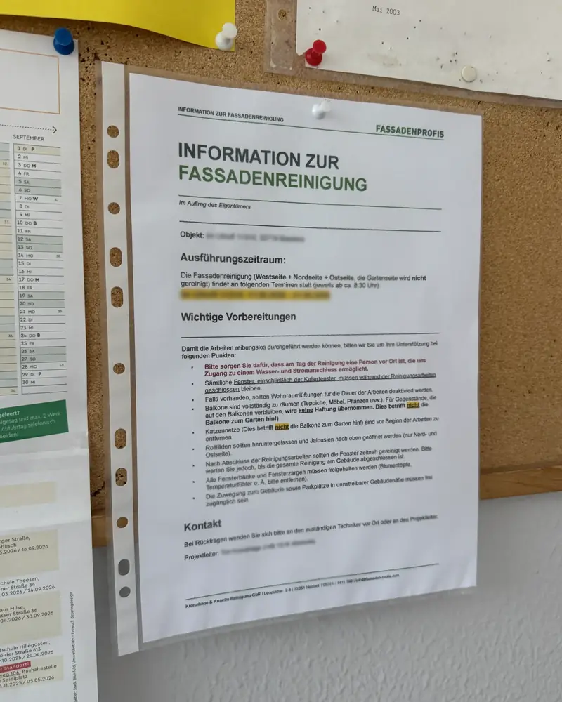 Aushang „Information zur Fassadenreinigung“ von FassadenProfis mit Ausführungszeitraum, Vorbereitungen für Bewohner und Kontakt, an einer Pinnwand im Treppenhaus