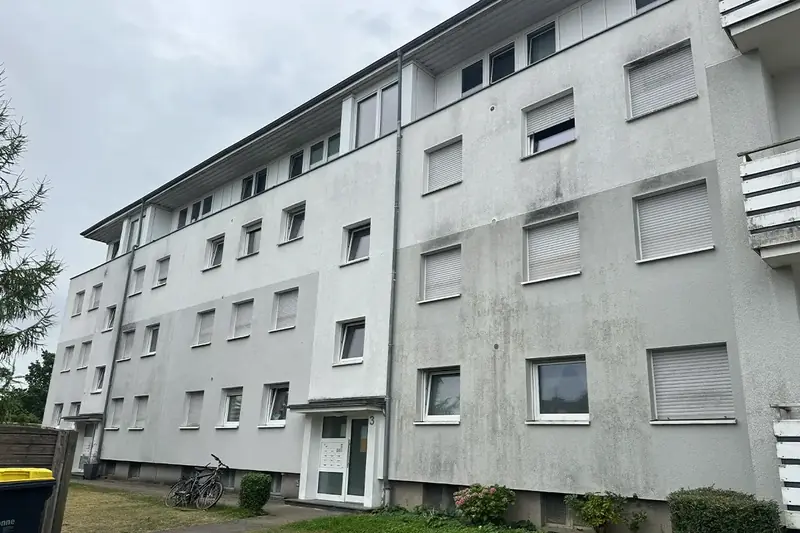 Mehrfamilienhaus in Bielefeld-Heepen mit deutlich sichtbarem Algenbewuchs auf der WDVS-Fassade vor der Reinigung
