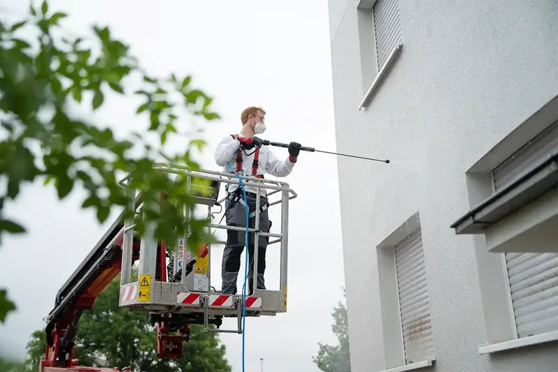 Hubsteiger im Einsatz bei der Fassadenreinigung eines Mehrfamilienhauses ohne Gerüst