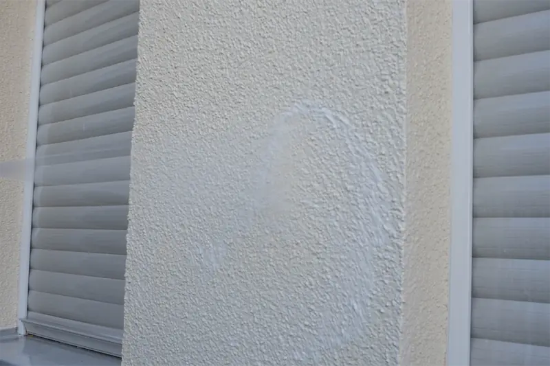 Helle, gereinigte Putzfassade neben einem Rollladen nach dem Auftragen von FP PROTECT